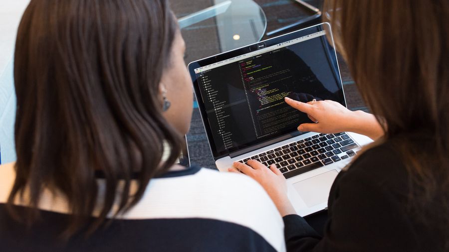 Security engineers reviewing source code together on a monitor